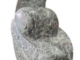 a stone sculpture of a reclining chair on a white background