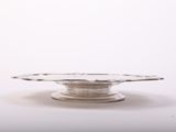 a silver plate on a white table with a white background