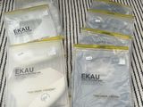 quatre paquets de masques Exaku sur un tissu rayé