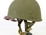 an old helmet with a chain on it is sitting on a stand