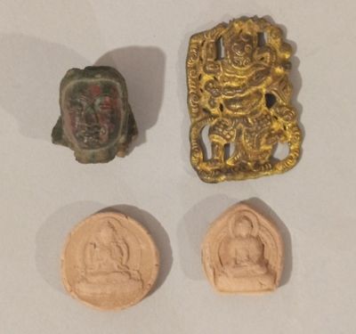 trois morceaux d'or et un petit morceau de bronze sur un fond blanc
