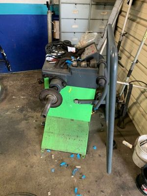une machine qui se trouve dans un garage, à côté d'une poubelle