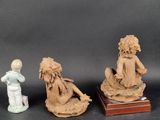 three figurines of a woman and a child sitting on a table
