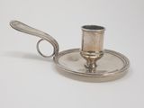 a silver plate with a silver candle holder on it