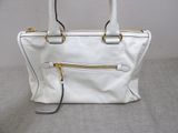 an image of a white handbag with gold handles