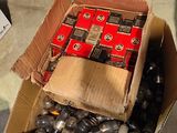 a cardboard box full of assorted batteries on the floor