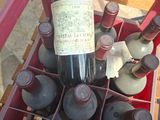 Les bouteilles de vin se trouvent dans une caisse rouge posée sur une table