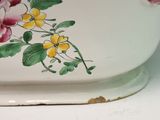 a white bowl with pink and yellow flowers painted on it