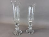 two clear glass vases sitting on top of a table