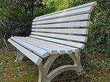 a white bench sitting in the middle of a grassy area