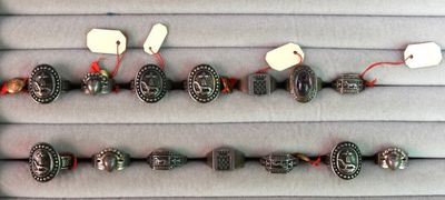 plusieurs types de bracelets différents, munis d'étiquettes, posés sur une table