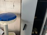 a refrigerator and a stool in the corner of a room