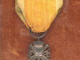 an old picture of a medal with a gold ribbon on a brown background