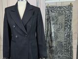 a suit and a skirt on a stand in a room