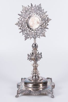 un plateau en argent surmonté d'une horloge, posé sur un socle