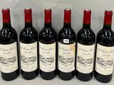 six bottles of red wine lined up in a row on a table