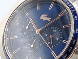 a close up of a watch with a blue face