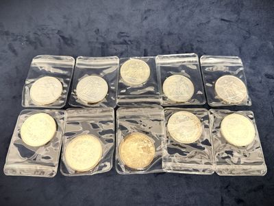 six different types of gold coins in plastic containers on a black surface