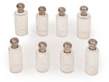 six small glass bottles with silver lids and silver tops