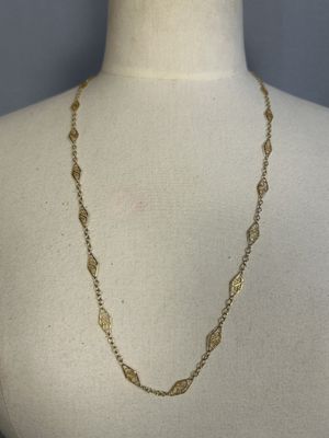 a close up of a mannequin torso wearing a gold necklace