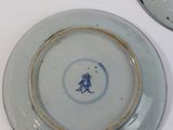 two plates with blue designs on them on a white table