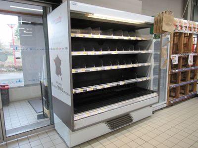 an empty refrigerator in the middle of a store