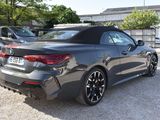the rear end of a black bmw convertible parked in a parking lot