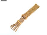a close up of a gold bracelet on a white surface
