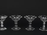 quatre verres à vin en cristal sont alignés sur une surface noire