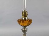 une lampe à huile à l'ancienne, surmontée d'un abat-jour en verre