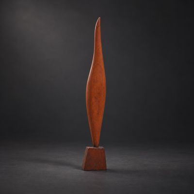 une sculpture en bois posée sur une surface noire, avec un arrière-plan sombre