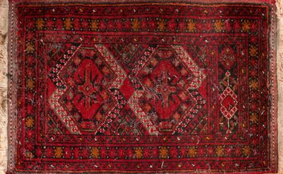 un vieux tapis persan aux motifs rouges et noirs