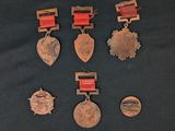 six medals and a medal are displayed on a black surface