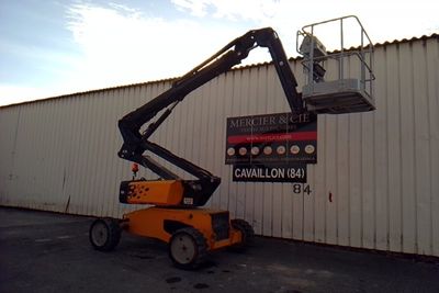 a picture of a man on a cherry picker in front of a building