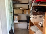 une photo d'une petite pièce avec de nombreuses boîtes sur les étagères