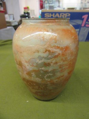 a vase sitting on a table with a box in the background