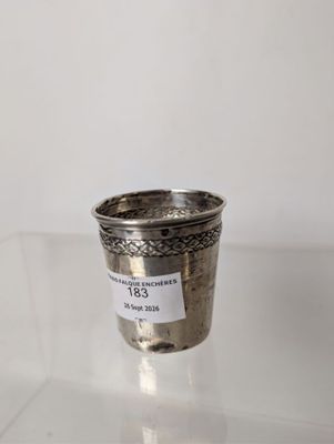 an old silver cup sitting on top of a glass table