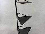a black metal shelf with three triangular shaped shelves on it