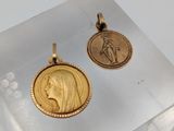 deux pendentifs en forme de pièces d'or représentant le visage d'une femme et la tête d'un homme