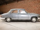 a silver car parked in a garage next to a brick wall
