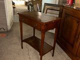 a small table with a drawer on it in a room
