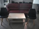une photo d'un salon avec deux fauteuils noirs et une table basse