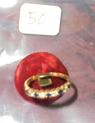 une bague en or sertie de pierres bleues et blanches