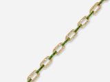 a close up of a gold bracelet with green and white stones