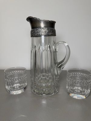 three glasses and a pitcher sitting on a table