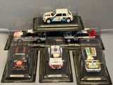five toy cars in a display case on a table