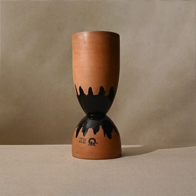un vase marron orné d'un motif noir, posé sur une table