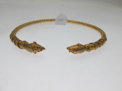 un gros plan sur un bracelet en or orné de deux têtes d'alligator