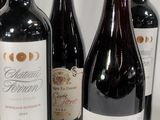 several bottles of wine are lined up on a white surface