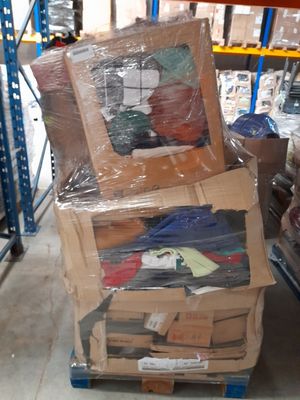 de nombreux cartons de vêtements posés sur une palette dans un entrepôt